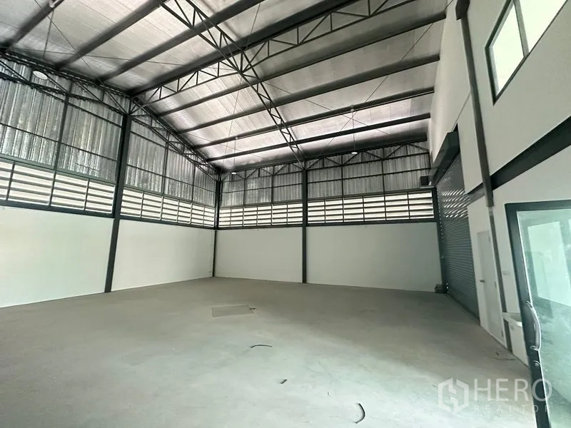 Factory for rent or sale in Bang Bua Thong, Nonthaburi - High‑ceiling factory hall with steel trusses, insulated roof and smooth concrete floor.