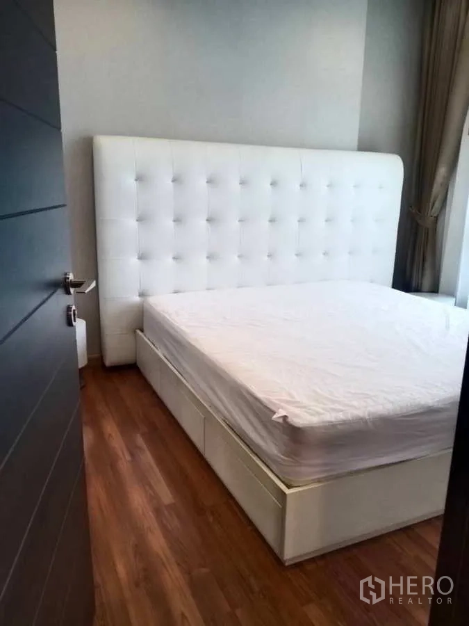 คอนโด ขายในHuai Khwang, Bangkok - ห้องนอนอบอุ่น เตียงหัวเตียงบุผ้าสีขาว พื้นไม้
