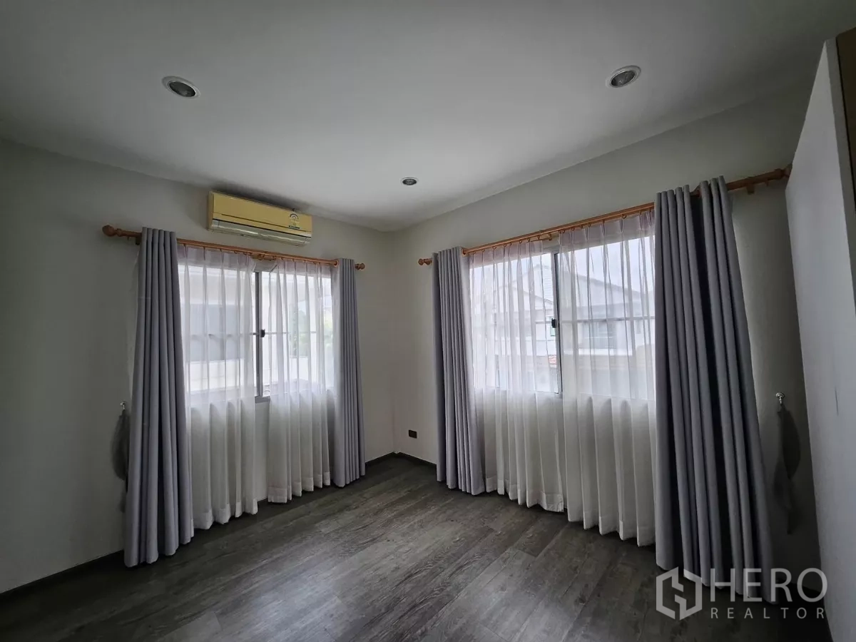 Detached House for rent in Khlong Toei, Bangkok - Corner bedroom with two bright windows and ceiling spotlights.