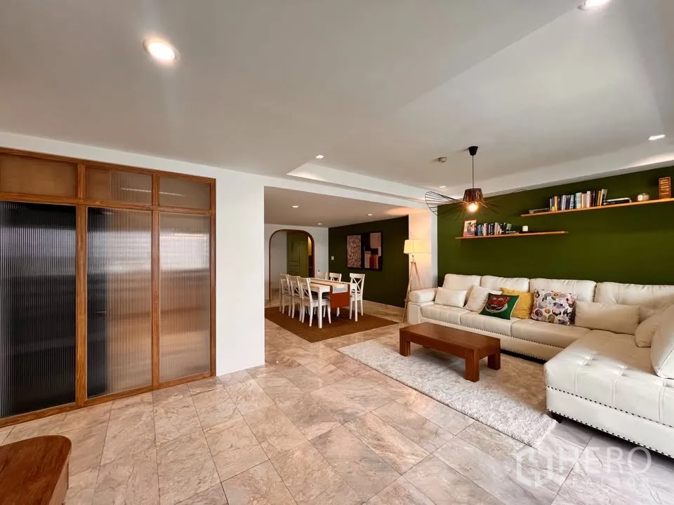 公寓 for rent in Watthana, Bangkok - 宽敞起居区，转角沙发、书架与用餐区。
