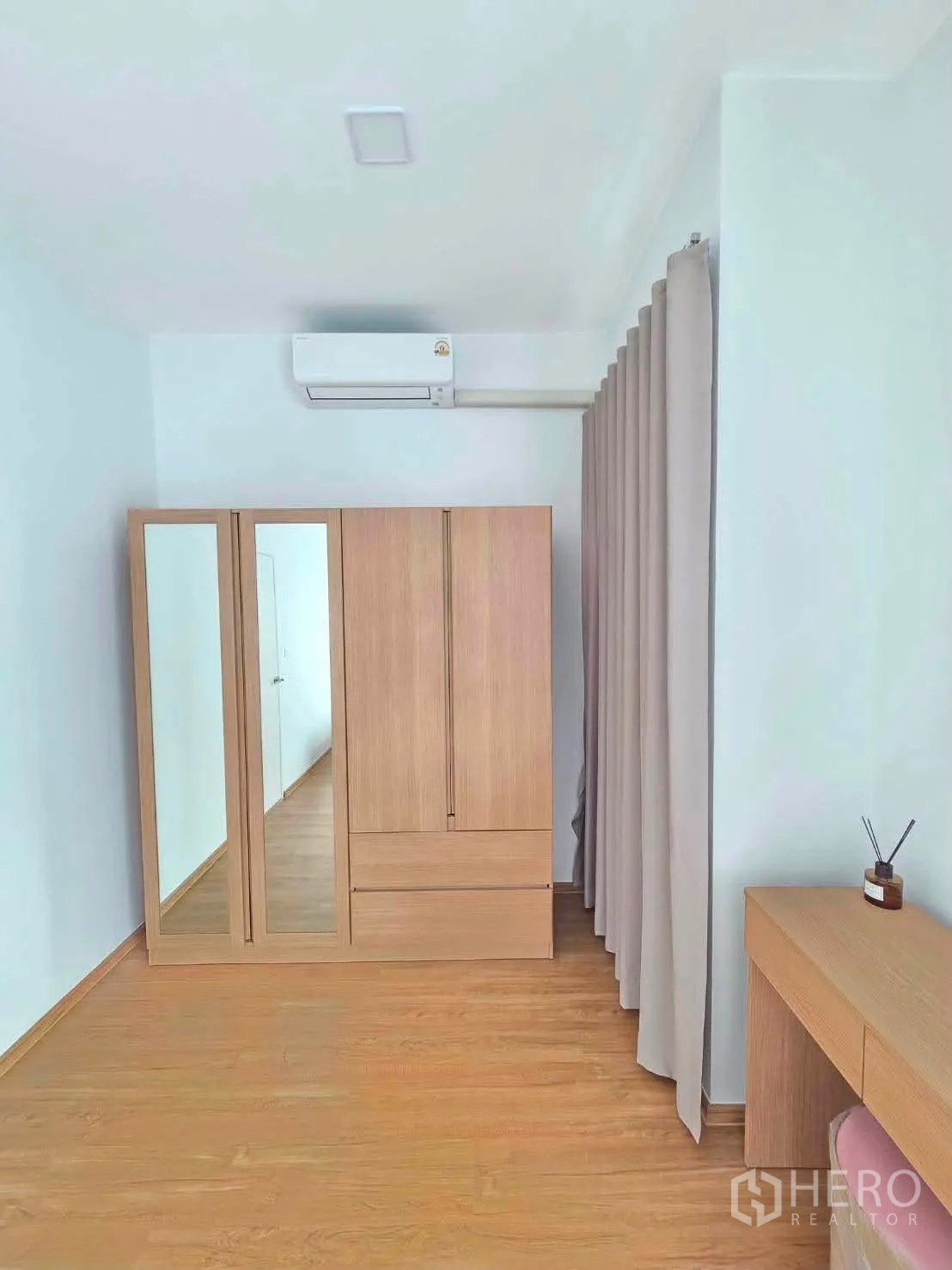 ทาวน์เฮาส์ for rent in Bang Phli, Samut Prakan - มุมห้องนอนมีตู้เสื้อผ้าไม้บานกระจกและโต๊ะเครื่องแป้ง.