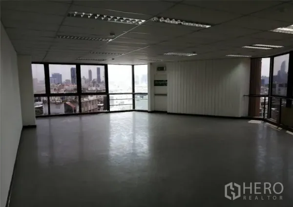 办公空间 出租在Pathum Wan, Bangkok - 宽敞办公区，转角环窗、紧急出口墙面与城市全景。