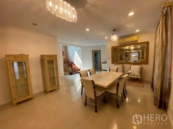 Detached House for rent in Bang Phli, Samut Prakan - Elegant dining room with chandelier lighting, marble-top table and glass display cabinets.