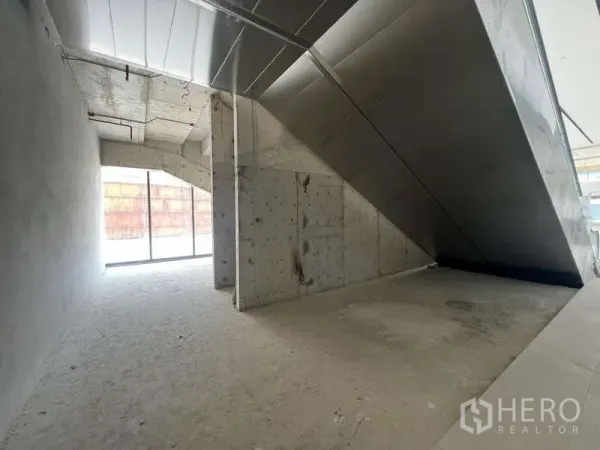 零售空间 出租 - 未装修零售室内，金属包覆楼梯下的开放空间与大面积玻璃门面