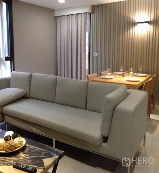 房间 出租在Khlong Toei, Bangkok - 现代客厅，灰色沙发、餐桌与落地窗帘