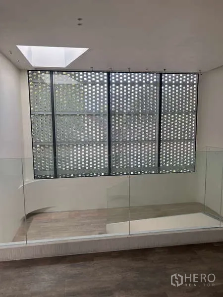 Standalone for rent in Khlong Toei, Bangkok - Modern white façade with full-height glass entrance on a busy city street.