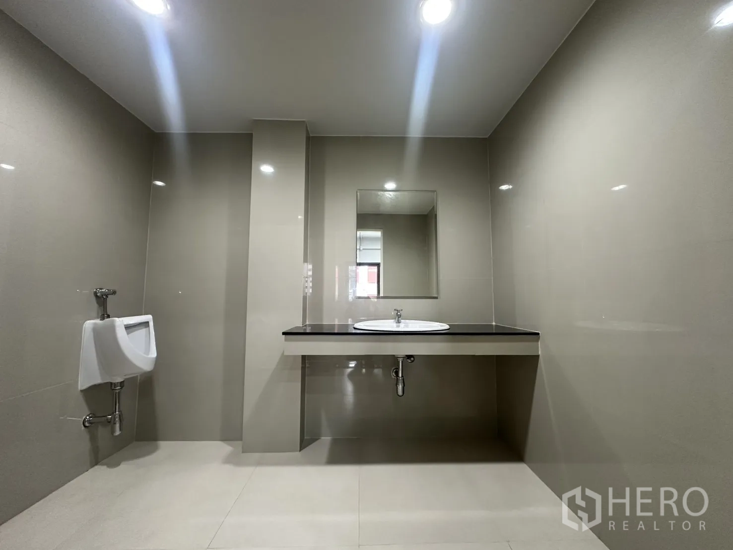 Office Space for rent in Watthana, Bangkok - Modern tiled bathroom with countertop basin, mirror, and urinal.