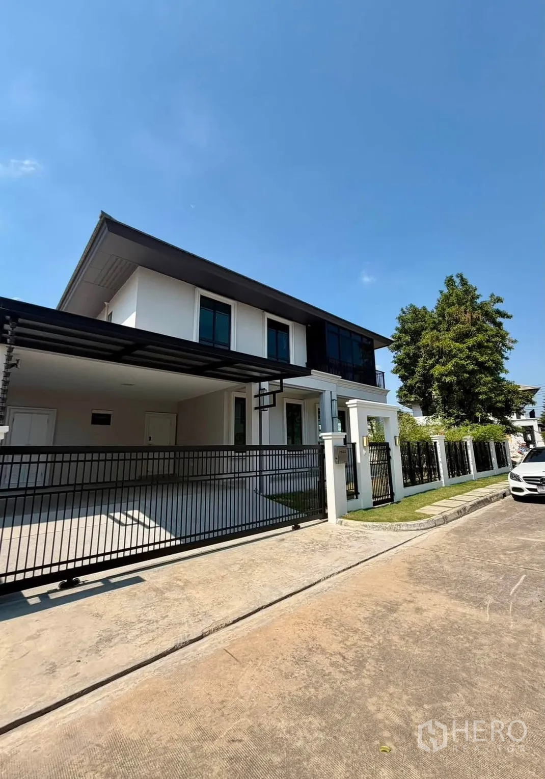 Detached House for rent or sale in Prawet, Bangkok - Modern two-storey facade with gated entry and covered carport.