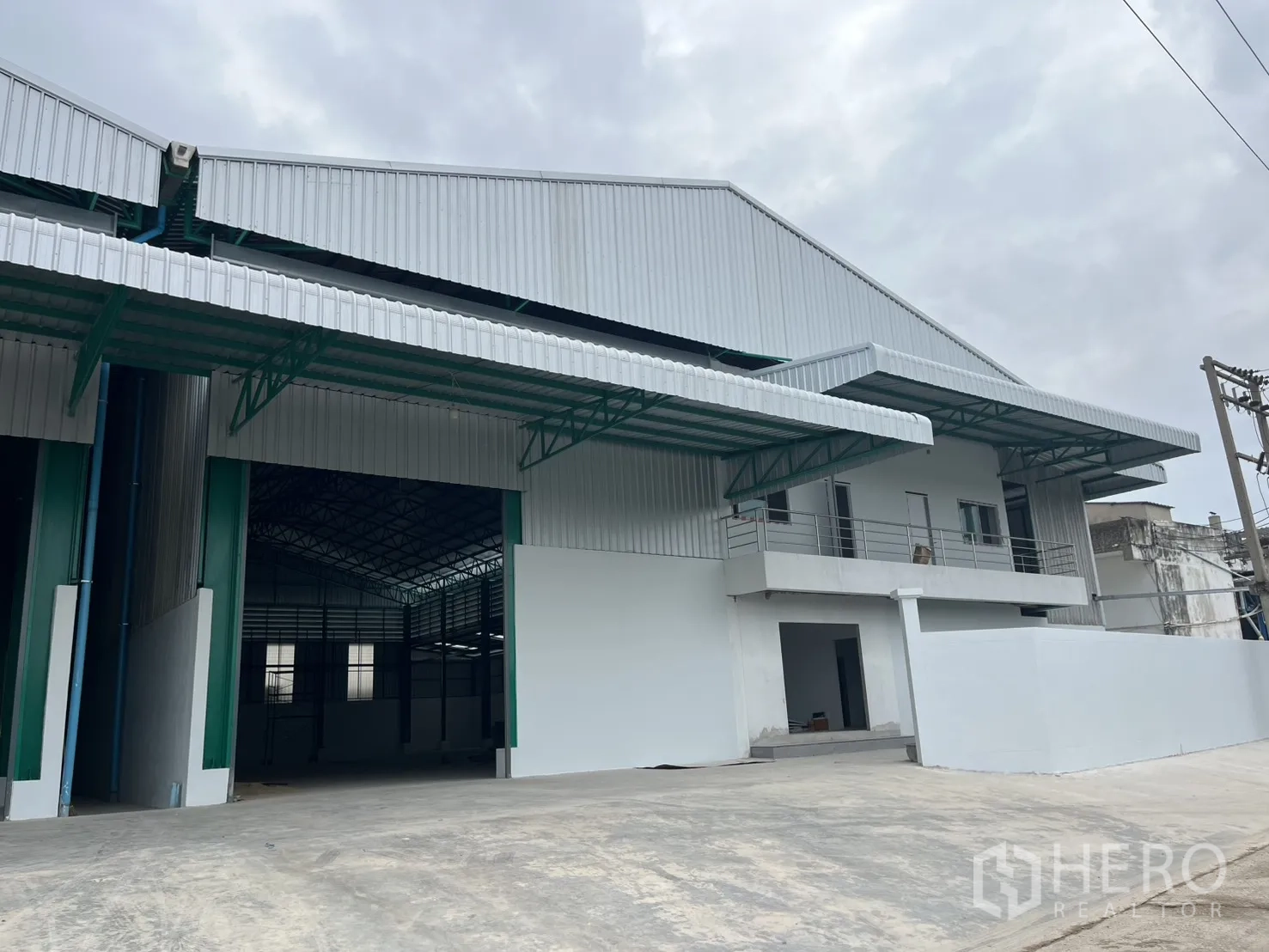 Warehouse for rent in Mueang Samut Sakhon, Samut Sakhon - Modern warehouse exterior with wide roller doors, covered loading canopies, balcony offices, and a concrete yard.