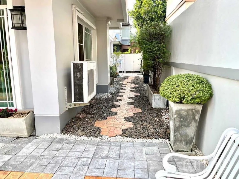 บ้าน ขายในSamut Prakan - ทางเดินข้างบ้านปูแผ่นทางเดินบนกรวด มีพุ่มไม้ตัดแต่งตลอดแนว