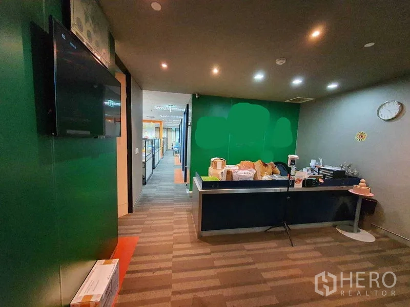 办公空间 出租在Watthana, Bangkok - 接待区，绿色背景墙、服务台与筒灯。