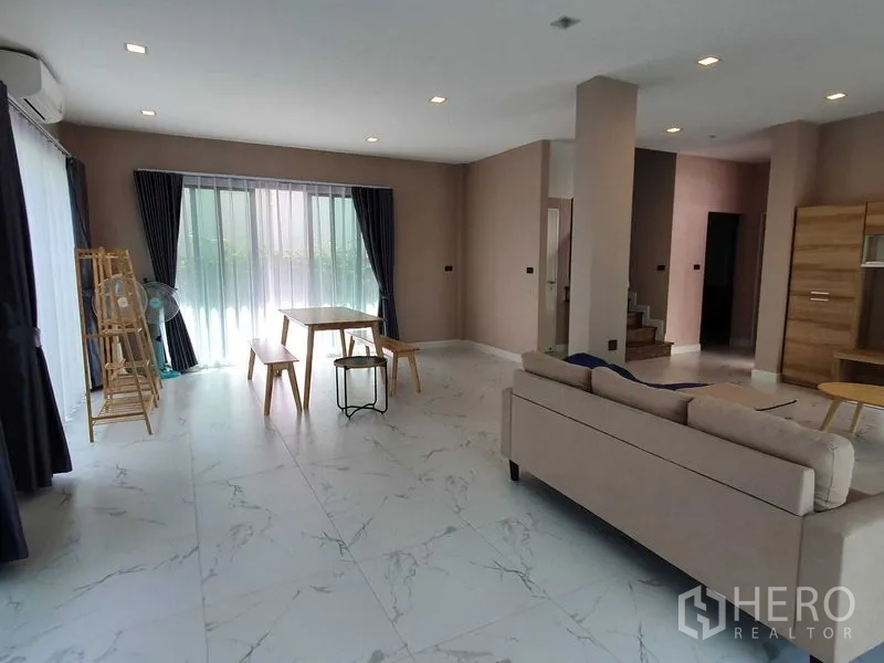 Detached House for rent in Khlong Luang, Pathum Thani - Open-plan living and dining zone with marble-look tiles and access to the staircase.