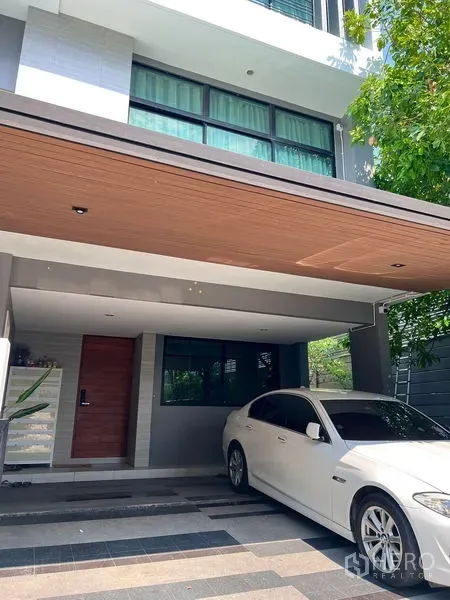 带办公室的家 出租在Saphan Sung, Bangkok - 现代多层家庭办公楼外观，带木质天花的遮蔽车位与大窗。