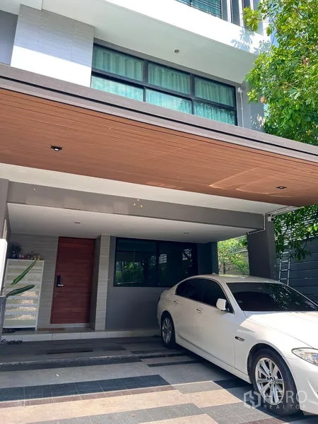 带办公室的家 出租在Saphan Sung, Bangkok - 现代多层家庭办公楼外观，带木质天花的遮蔽车位与大窗。