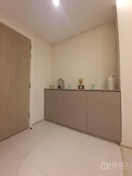 Condominium for rent in Khlong Toei, Bangkok - Minimal entry hall featuring a low built-in console and soft downlights.