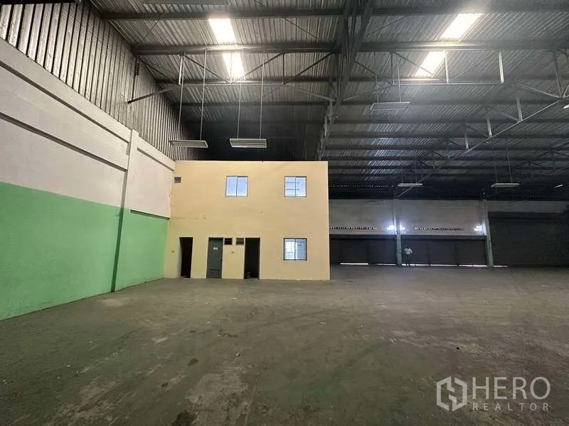 Factory for rent in Nonthaburi - Close-up of internal two-storey office rooms and service doors within the warehouse.