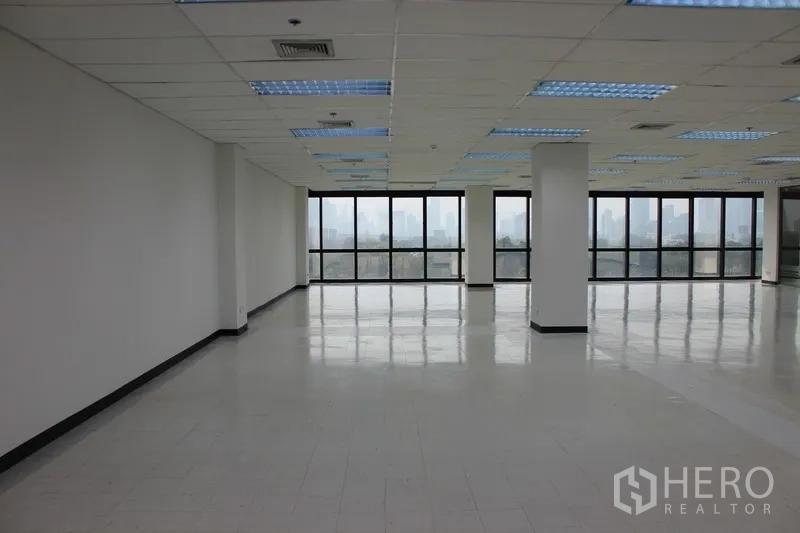 办公空间 出租在Watthana, Bangkok - 宽敞的开放式办公楼层，格栅吊顶与整面窗户。