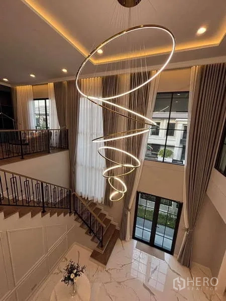 บ้าน ให้เช่าในBang Phli, Samut Prakan - โถงเพดานสูงสองชั้น โคมไฟทรงเกลียว ผ้าม่านสูง และบันได