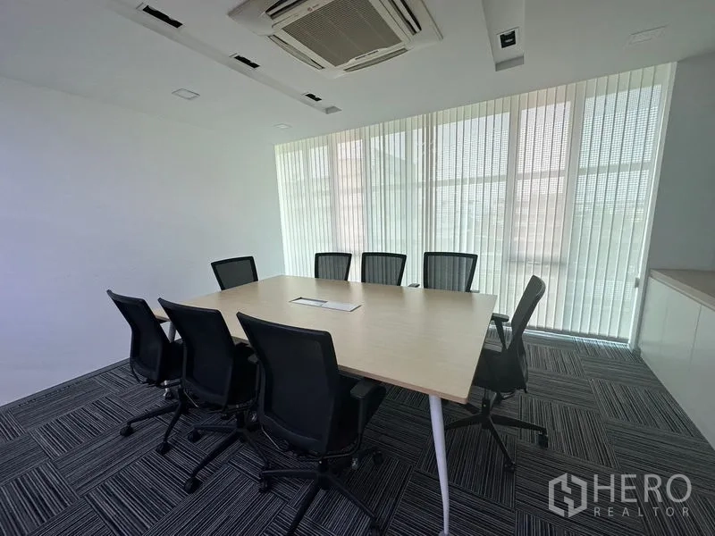 Office Space for rent - Narrow conference room with long table, red chairs and glass wall overlooking offices.
