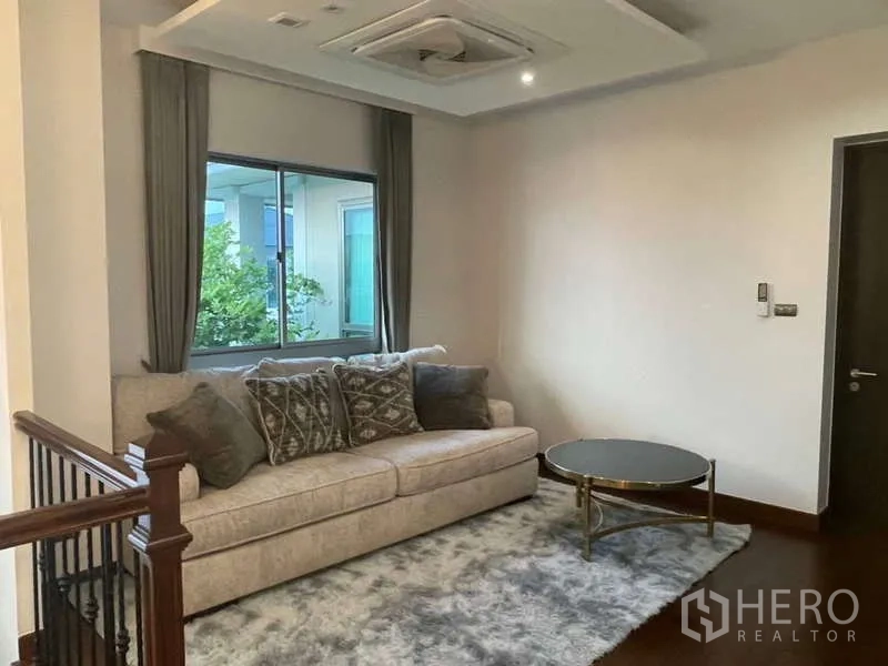 Detached House for rent or sale in Lat Krabang, Bangkok - Cozy upstairs lounge with a sofa, window views and a round coffee table on a plush rug.