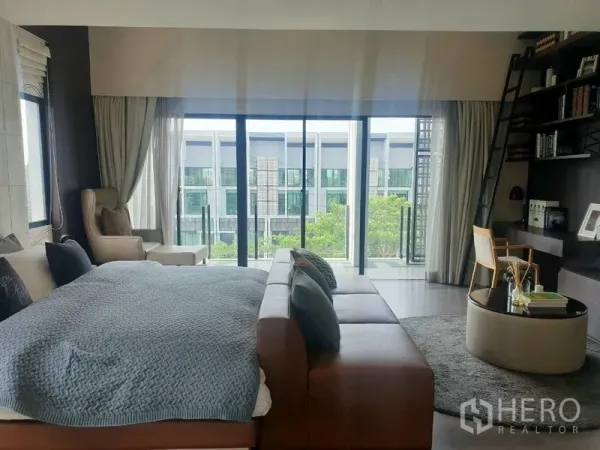 Home Office for rent - Spacious master suite with sofa seating, shelving and floor‑to‑ceiling glass.