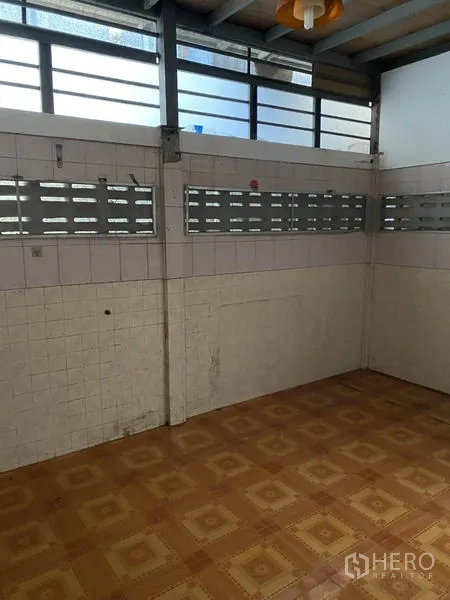 Townhouse for rent in Lat Phrao, Bangkok - Tiled multipurpose room with ventilation blocks and patterned vinyl flooring.