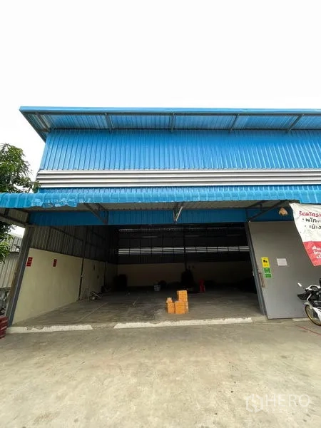 货栈 出租在Khlong Luang, Pathum Thani - 空銮蓝色金属外墙仓库外观，宽敞入口与带顶装卸区