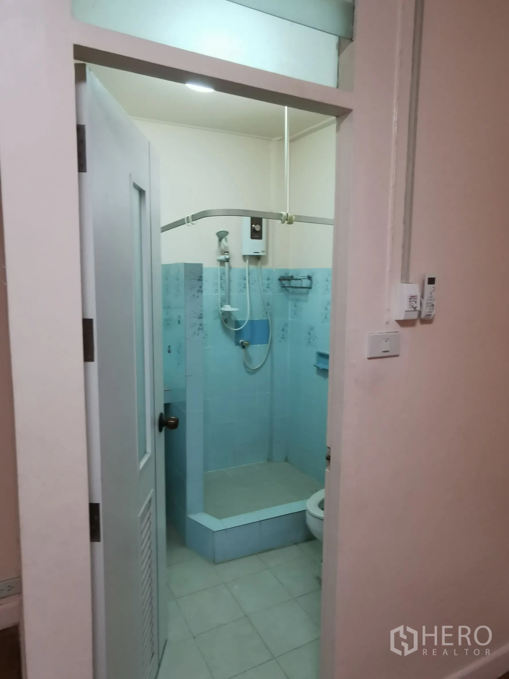 联排别墅 出租在Khlong Toei, Bangkok - 浴室，蓝色瓷砖淋浴区、热水器与坐便。