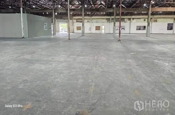 Warehouse for rent in Lam Luk Ka, Pathum Thani - Interior zone with smooth concrete slab, small internal office block and roller door openings.