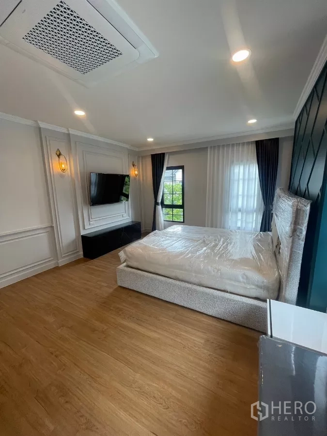 Detached House for rent in Bang Phli, Samut Prakan - Spacious master bedroom with TV wall, large windows and soft lighting.
