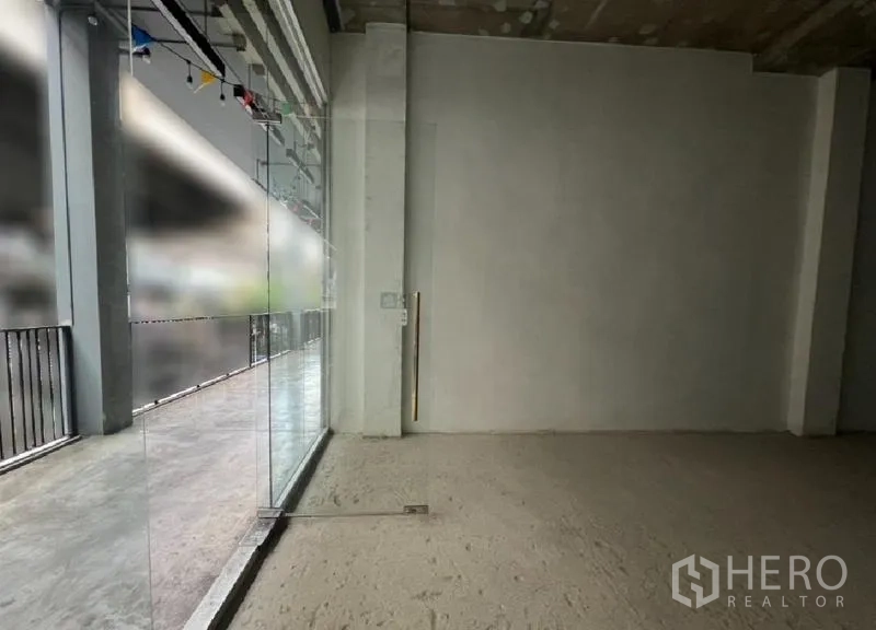 Retail Space for rent in Khlong Toei, Bangkok - Empty retail shell with full-height glass frontage opening to the covered walkway.