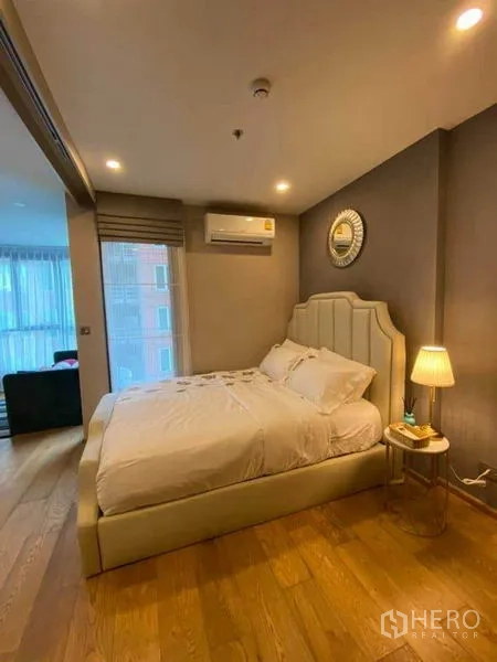 公寓 出售在Ratchathewi, Bangkok - 卧室配软包床、床头灯、空调与纱帘落地窗。