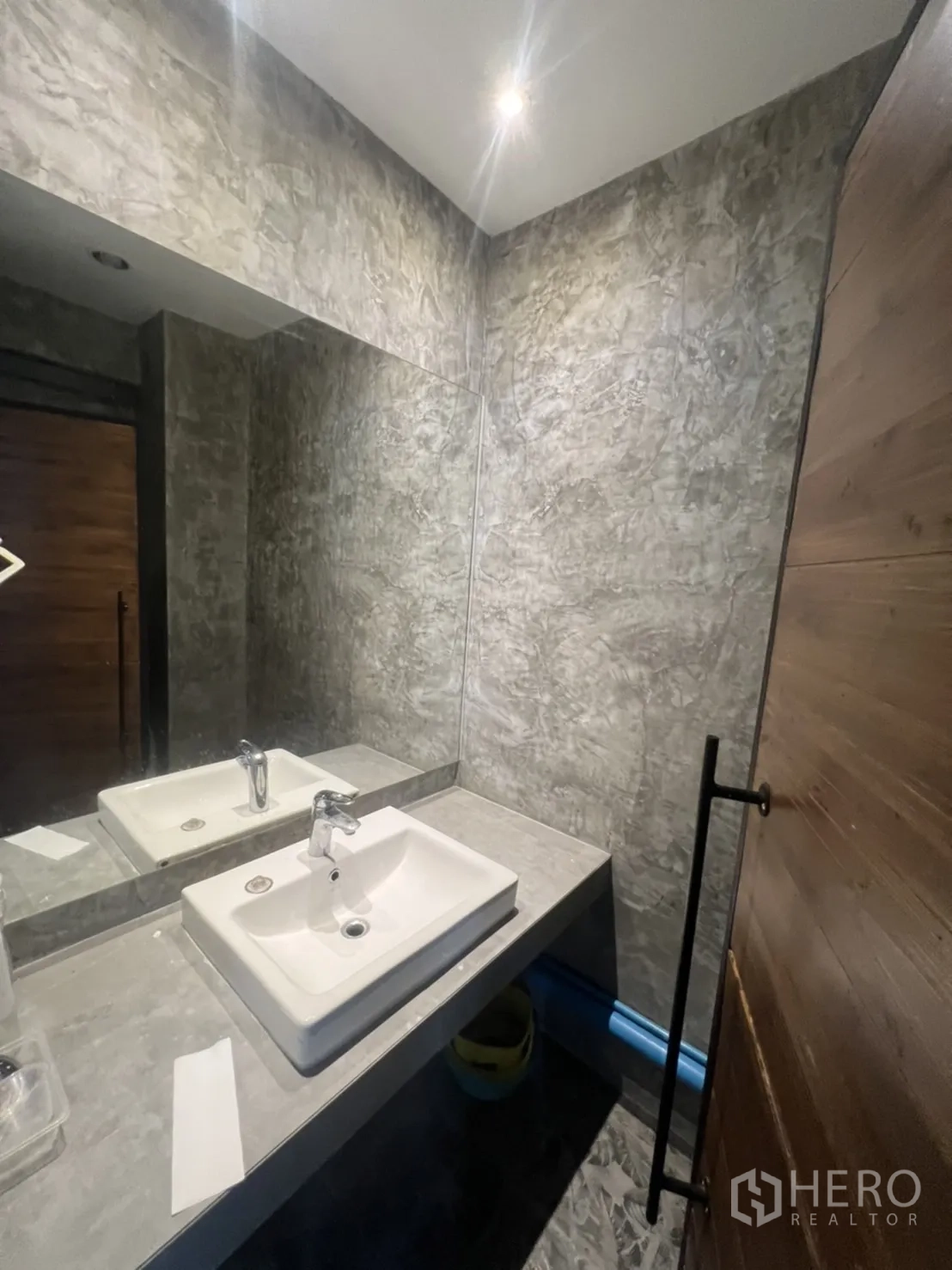 Retail Space for rent in Watthana, Bangkok - Contemporary restroom with polished concrete walls, large mirror and rectangular basin.