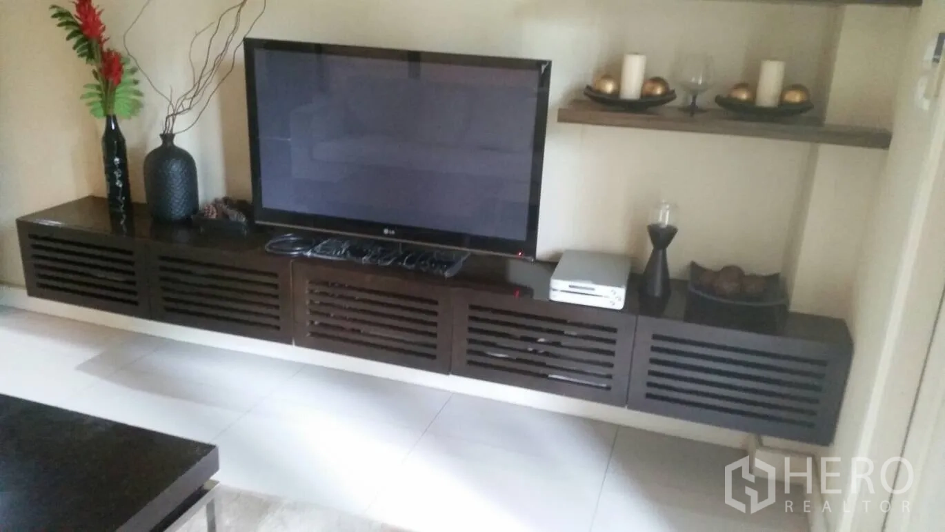 Detached House for rent in Lat Krabang, Bangkok - Living room media wall with flat‑screen TV on dark wood console and decorative shelves.