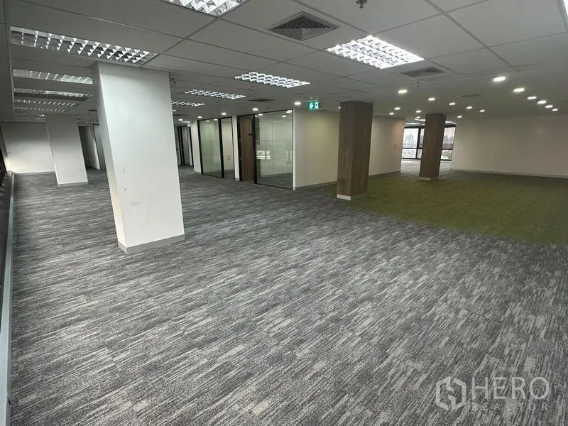 办公空间 出租在Khlong Toei, Bangkok - 开阔办公区，展示玻璃隔断与绿色地毯协作区。