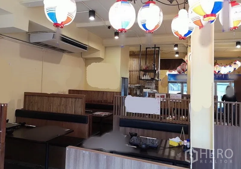 店屋 出租在Watthana, Bangkok - 商铺室内餐饮布局，木质卡座、悬挂灯笼、服务台与空调设备。