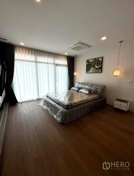 บ้าน ให้เช่าในSamut Prakan - ห้องนอนมาสเตอร์พร้อมโคมแขวนและผ้าม่านโปร่งเต็มผนัง