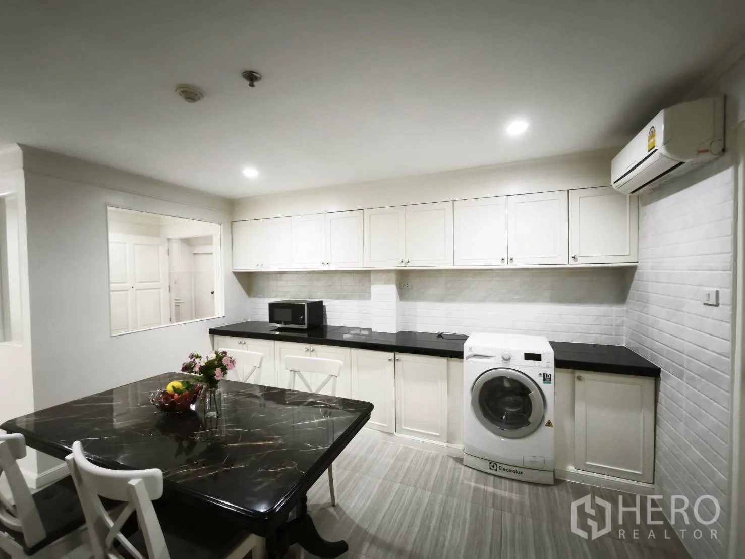 คอนโด for rent in Watthana, Bangkok - ผนังครัวพร้อมเคาน์เตอร์ยาว ตู้ลอย เครื่องซักผ้า ไมโครเวฟ และโต๊ะทานอาหาร