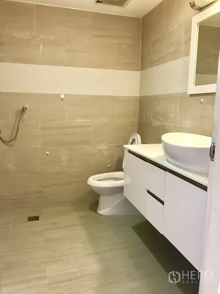 Condominium for rent in Watthana, Bangkok - Master bedroom with platform bed, padded headboard and dressing table.