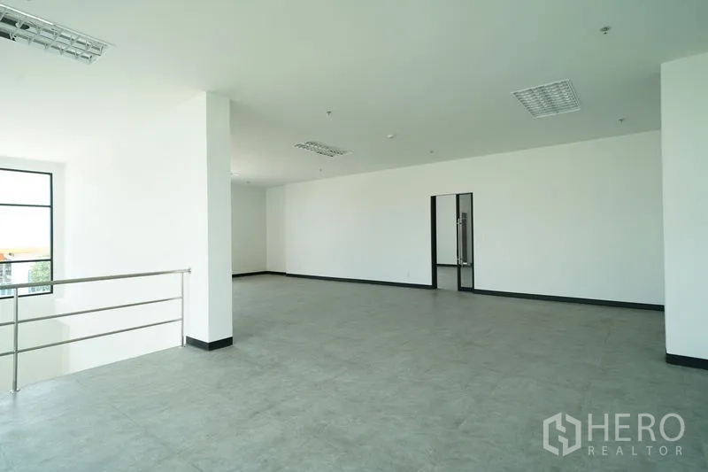 Warehouse for rent in Khlong Luang, Pathum Thani - Open-plan office level with railings, tiled floors, and a glass-door meeting room.