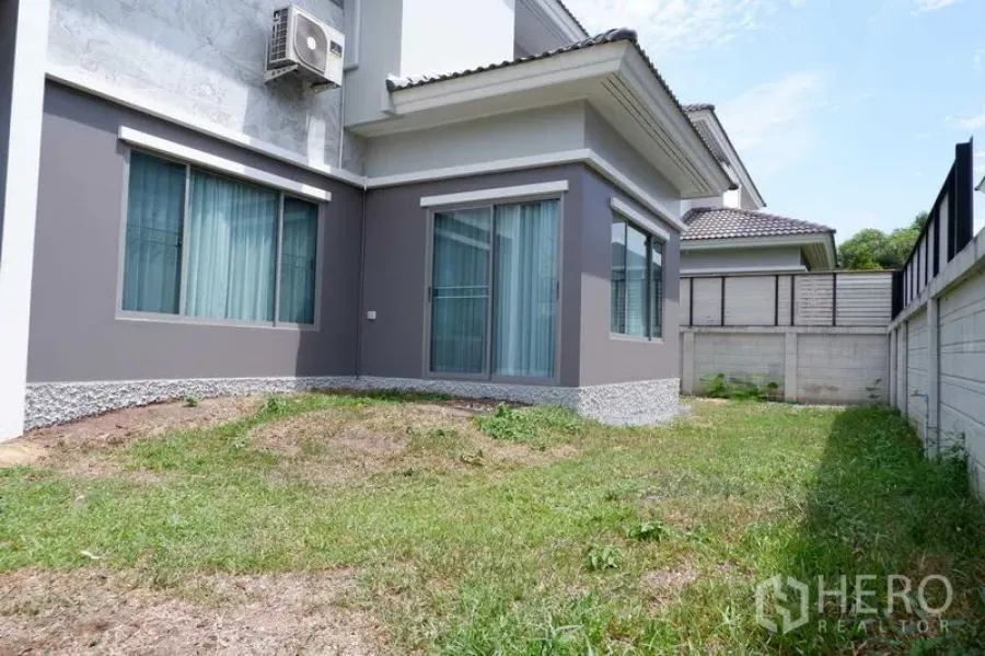 独立式住宅 出售在Lat Krabang, Bangkok - 曼谷叻甲挽两层独栋住宅的侧院草地与推拉落地门