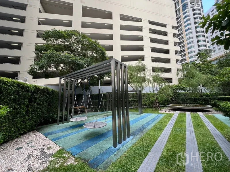 Condominium for sale - Garden playground with suspended swings and blue-green rubber flooring.
