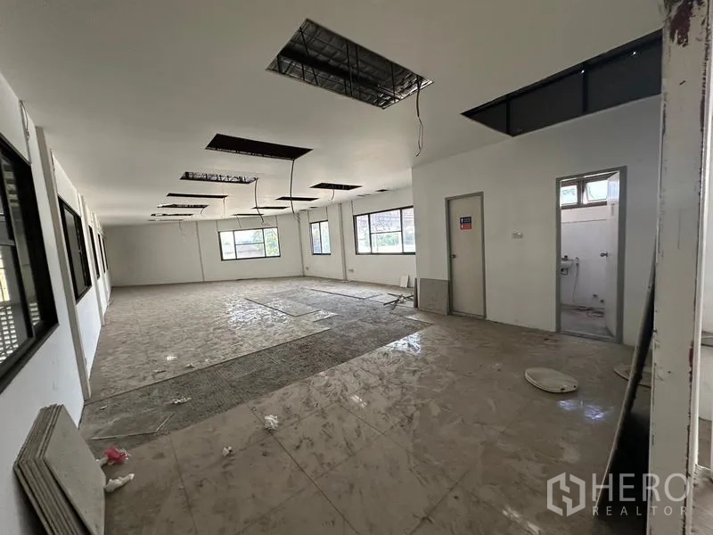Warehouse for rent in Suan Luang, Bangkok - Upper office space with windows and adjoining restroom under renovation.