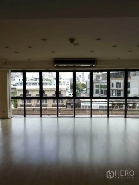 办公空间 出租在Khlong Toei, Bangkok - 开放式工作区，通高落地窗、嵌入式灯光与城市景观。