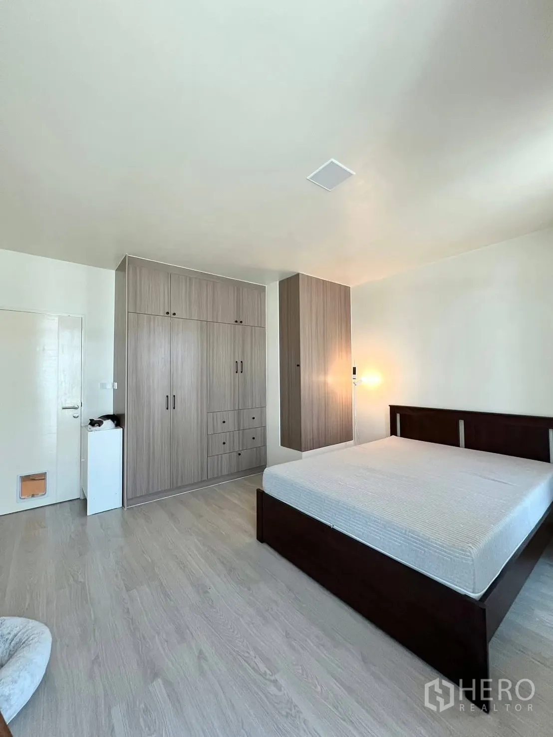 ทาวน์เฮาส์ for rent in Bang Phli, Samut Prakan - ห้องนอนหลักพร้อมเตียงใหญ่ ตู้เสื้อผ้าหลายบาน และพื้นไม้ลามิเนต