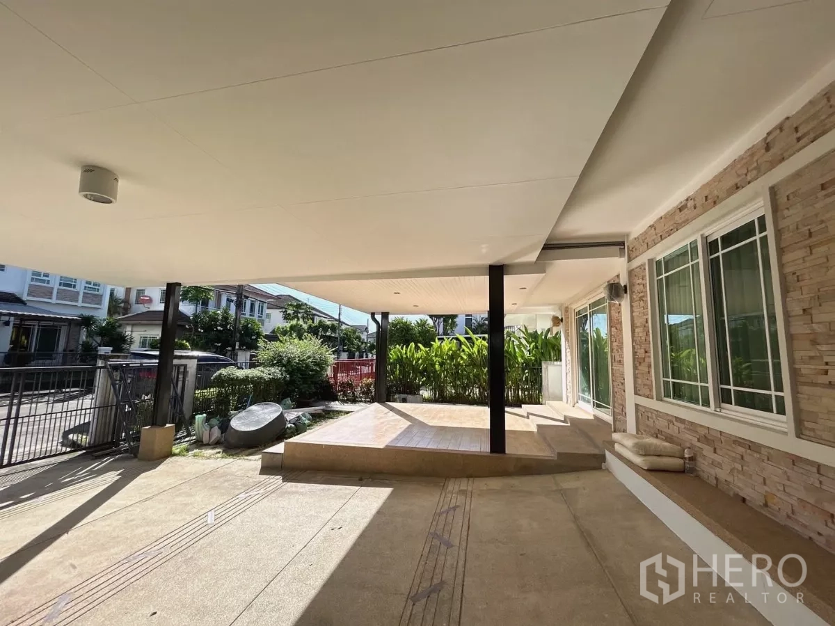 Detached House for sale in Bang Kapi, Bangkok - Shaded carport and raised terrace leading to sliding glass doors into the living room.