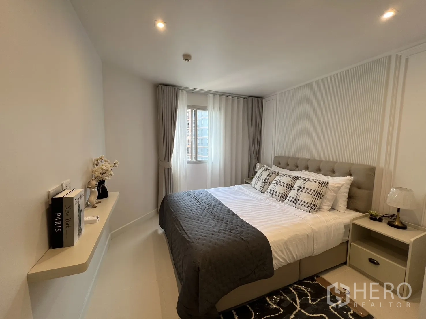 Condominium for rent in Yan Nawa, Bangkok - Cozy bedroom with upholstered bed, bedside table, and small window with drapes.