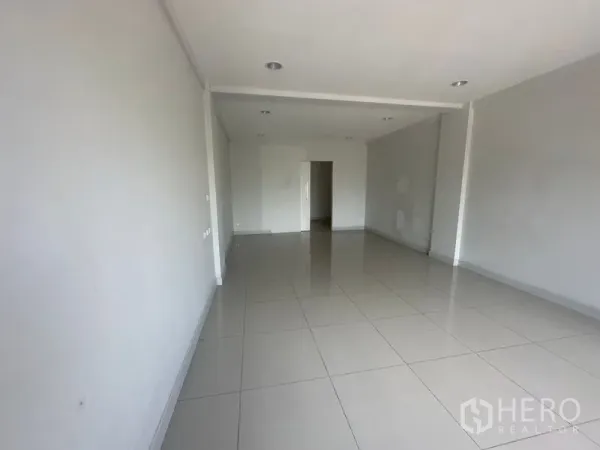 Home Office for rent in Bang Na, Bangkok - Empty open-plan room with glossy tiles and recessed ceiling lights.