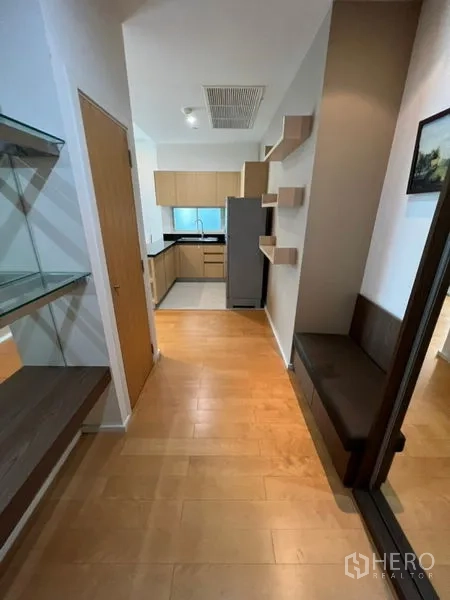 Condominium for rent in Chatuchak, Bangkok - Entrance hallway with built-in shelves leading to U-shaped kitchen and refrigerator
