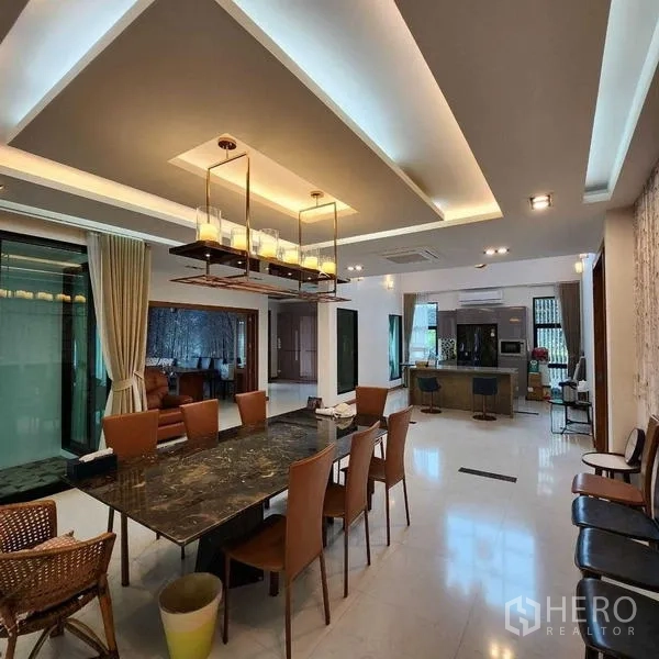 独立式住宅 出售在Phra Khanong, Bangkok - 开放式餐厅，层次吊顶、吊灯与长条大理石餐桌